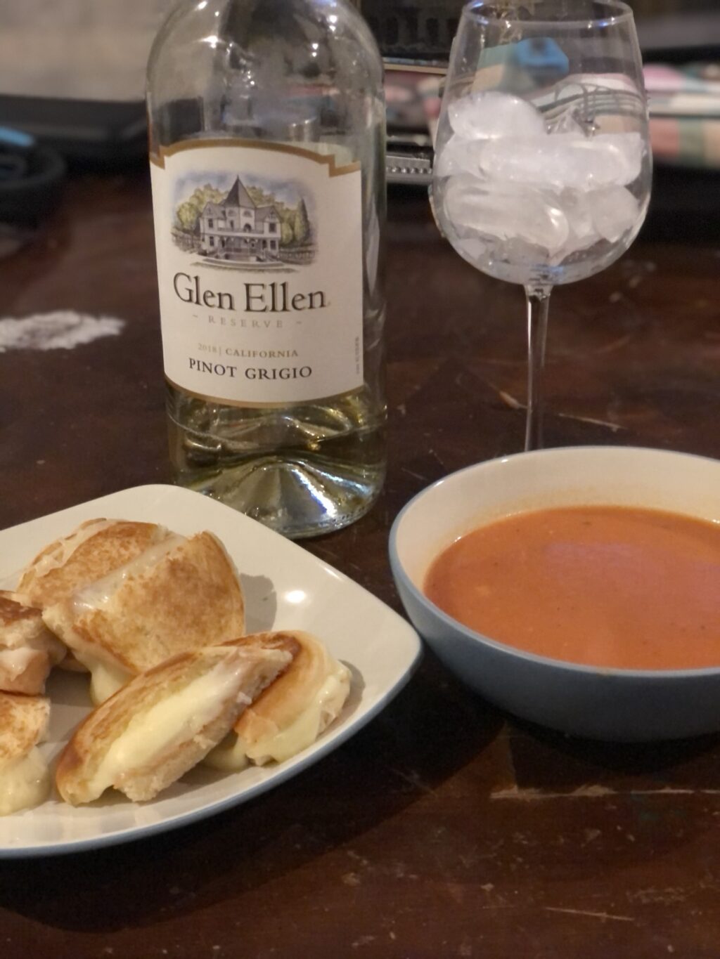 Crispy grilled cheese on toasted sourdough bread with gooey melted cheese, served alongside classic tomato soup.